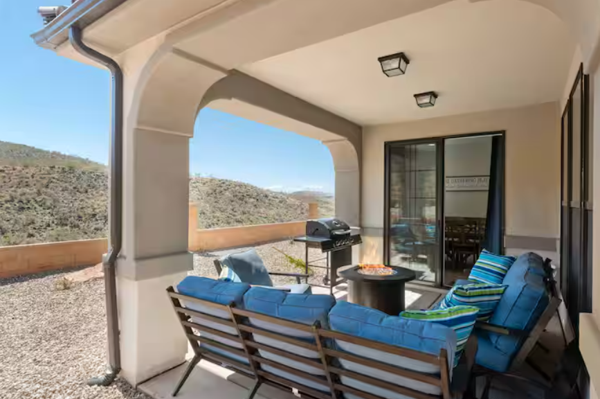Covered patio with comfortable seating, fire pit, and mountain views