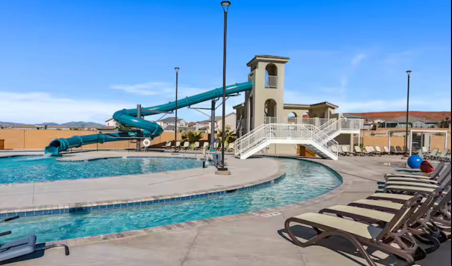 Resort-style pool with water slide and lounge chairs at the retreat property